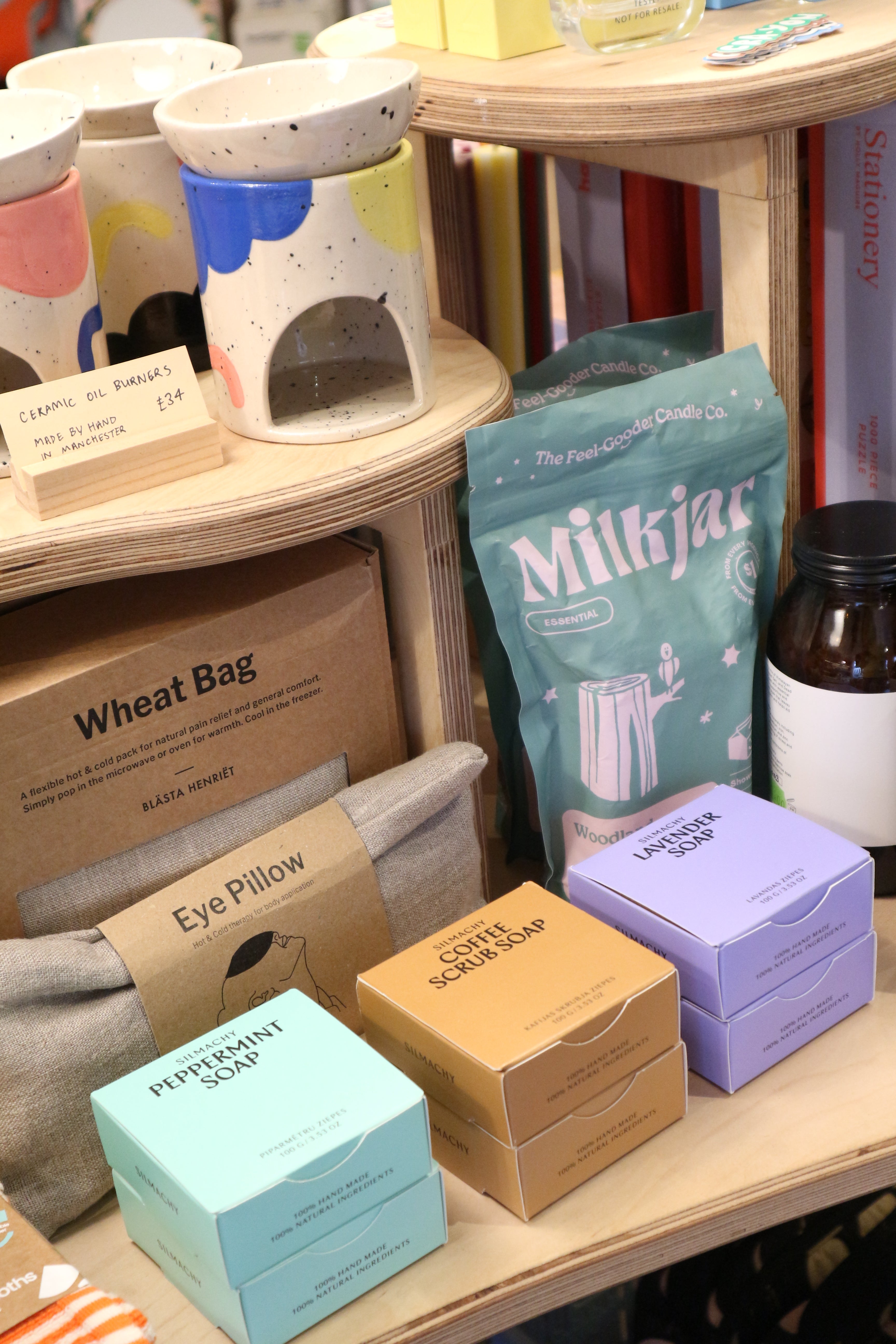 Various items including a wheat bag, soap bars, and a milk jar on a shelf.